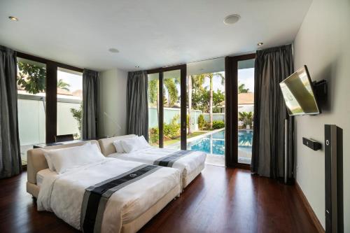 a bedroom with a large bed and a swimming pool at C151 Smart Villas at Seminyak in Seminyak