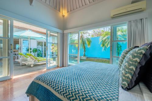Un dormitorio con una cama y una ventana grande. en THE CABANA, en Sanur