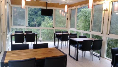 a room with tables and chairs and large windows at Sunlight Forest in Dahu