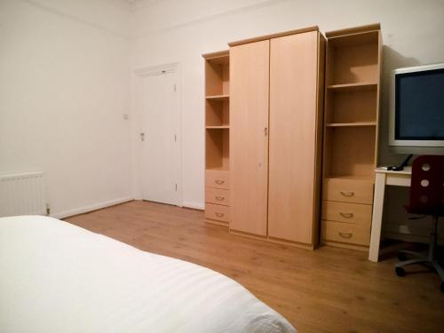 a bedroom with a bed and a desk with a television at OutRam 26 in Stockton-on-Tees