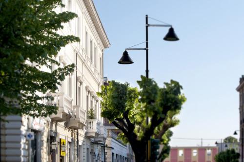 a street light and a tree on a city street at Dimora Novecento in Pescara