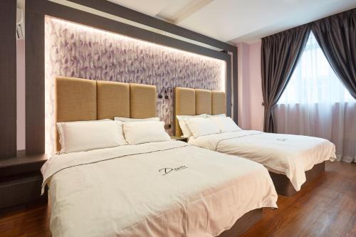 two beds in a room with pink walls at DREAM LUXURY HOTEL in Muar