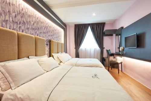 a hotel room with two beds and a television at DREAM LUXURY HOTEL in Muar