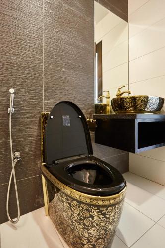 a bathroom with a black and gold toilet and a sink at DREAM LUXURY HOTEL in Muar
