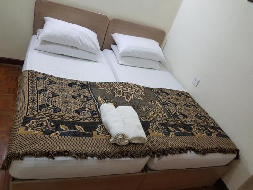 バトゥ・フェリンギにあるHome stay Bayu Emas Appartment, Batu Ferringhiのベッド(白い枕、タオル付)