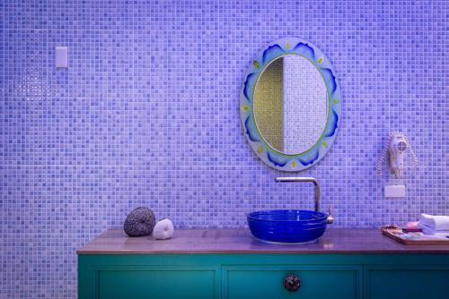a bathroom with a blue sink and a mirror at Vogue Boutique Motel in Yangmei