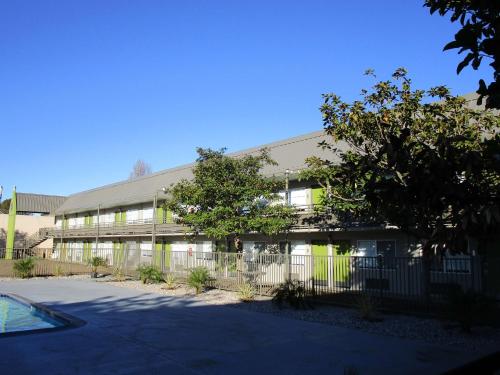 an office building with a fence in front of it at SureStay Plus Hotel by Best Western Point Richmond in Richmond