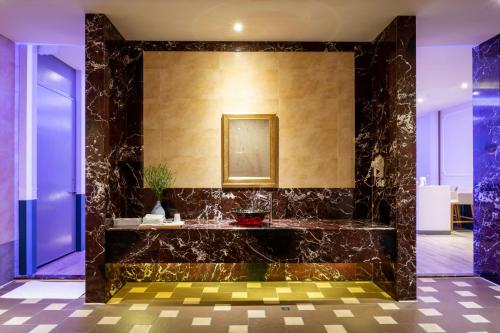 a bathroom with a sink and a mirror on a wall at Vogue Boutique Motel in Yangmei