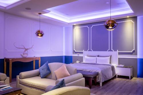 a bedroom with a bed and a couch at Vogue Boutique Motel in Yangmei