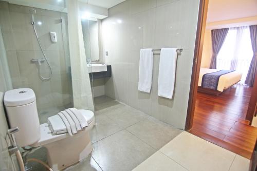 a bathroom with a shower and a toilet and a sink at The Legian Sunset Residence in Seminyak