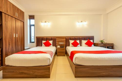 a bedroom with two beds with red pillows at Westlake Tay Ho Hotel 696 Lạc Long Quân in Hanoi