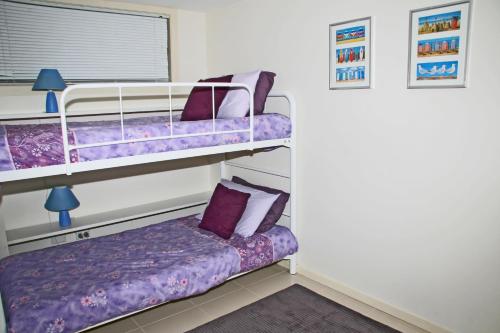 a bedroom with two bunk beds and a couch at Blueys Apartment @ 192 Boomerang Drive in Blueys Beach