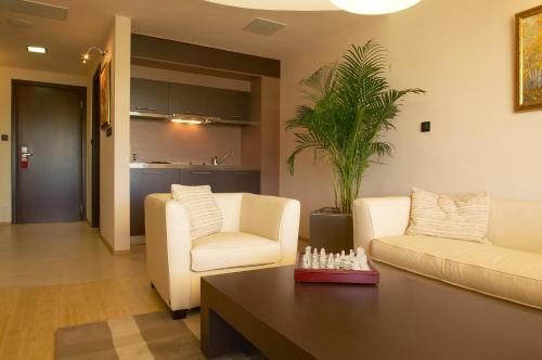 a living room with two chairs and a coffee table at Park Hotel Green Europe in Haskovo