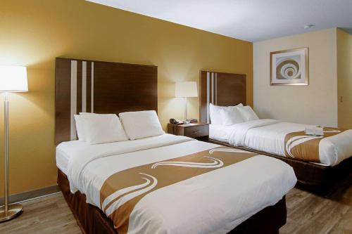 a hotel room with two beds and two lamps at Quality Inn Plainfield I-395 in Plainfield