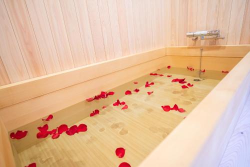 a room with red rose petals on the floor at Kyomachi Rakunan in Kyoto
