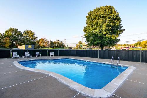 a swimming pool with two chairs and a fence at Quality Inn Plainfield I-395 in Plainfield