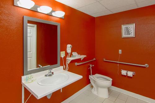 an orange bathroom with a sink and a toilet at Quality Inn Plainfield I-395 in Plainfield