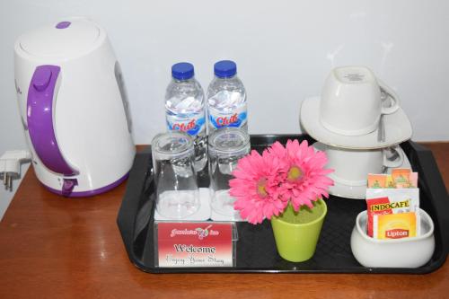 a tray with bottles of water and a flower on a counter at Jambura Inn in Gorontalo