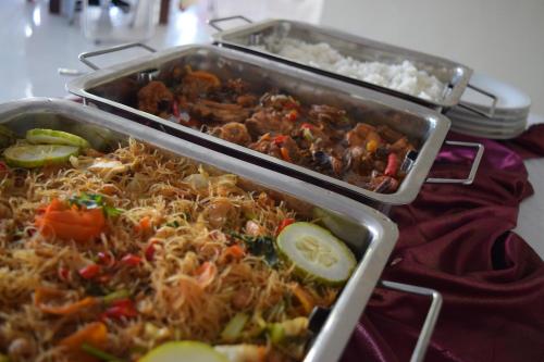 two trays of food on a table with rice at Jambura Inn in Gorontalo