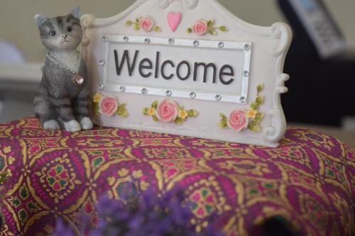 a cake with a cat sitting on a bed with a welcome sign at Jambura Inn in Gorontalo
