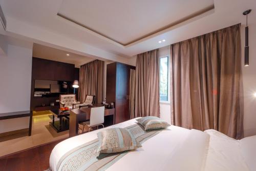 a hotel room with a bed and a living room at Ambara Suites in Trivandrum
