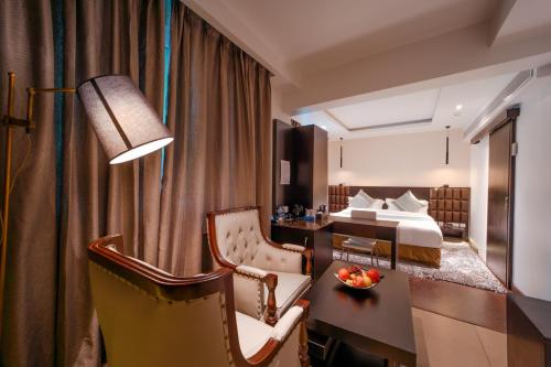 a hotel room with a bed and a desk at Ambara Suites in Trivandrum
