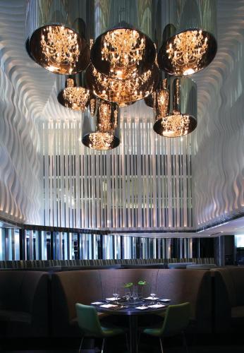 a chandelier in a restaurant with a table and chairs at The Mira Hong Kong in Hong Kong