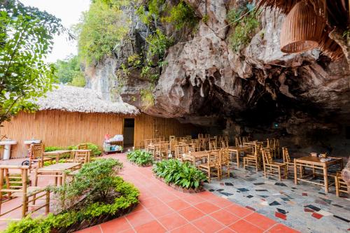 a restaurant with chairs and tables in a cave at Tam Coc Horizon Bungalow in Ninh Binh