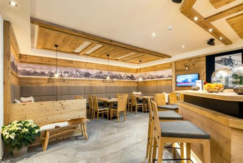 a restaurant with wooden walls and tables and chairs at Alpin Chalet am Burgsee in Ladis
