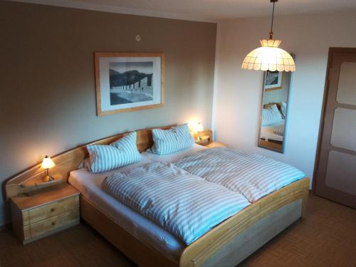 オーバーハルマースバッハにあるLangenberghofのベッドルーム(ランプ2つ付)の大型ベッド1台