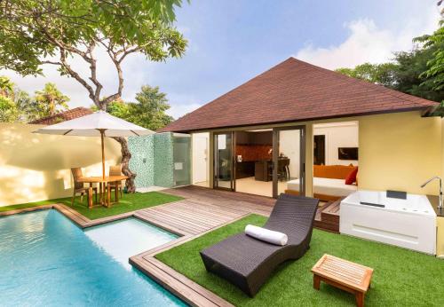a backyard with a swimming pool and a villa at Downtown Villas in Seminyak