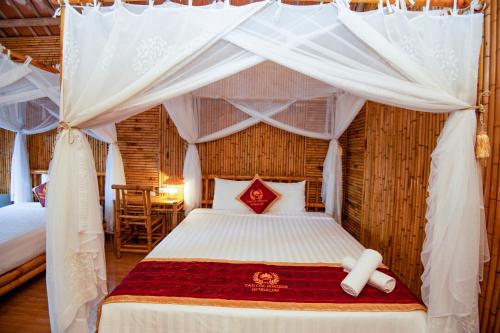 a bedroom with a bed with a canopy at Tam Coc Horizon Bungalow in Ninh Binh