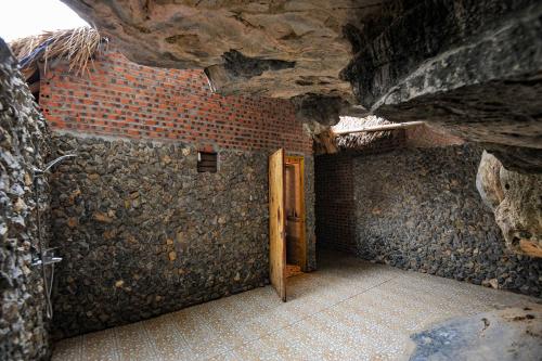 a room with a door in a brick wall at Tam Coc Horizon Bungalow in Ninh Binh