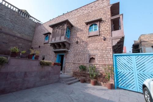 a brick building with a blue gate in front of it at Baijoo Niwas in Jodhpur