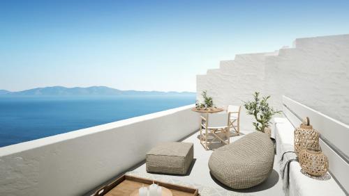 a balcony with chairs and a view of the ocean at Living Theros Luxury Suites in Kardiani