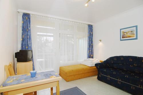 uma sala de estar com um sofá e uma janela em Kosztolányi Apartmanház em Balatonfüred