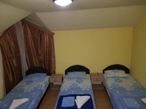 a small room with two beds and two tables at Motel Magistrala in Doboj