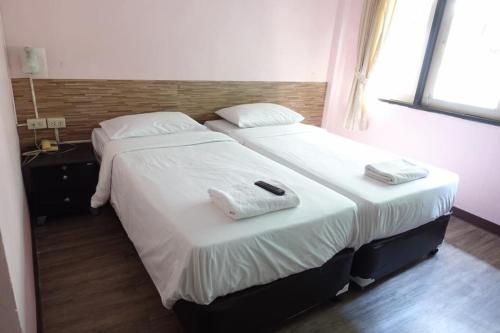 two beds in a hotel room with towels on them at Rajparop PLace in Bangkok