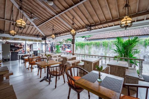 a dining room with tables, chairs, and tables with umbrellas at Natya Hotel Tanah Lot in Tanah Lot