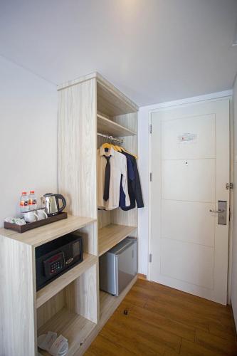 a room with a closet with wooden shelves and a door at Front One Akshaya Hotel Karawang in Karawang