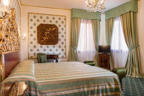a hotel room with a bed and a chandelier at Hotel Giorgione in Venice