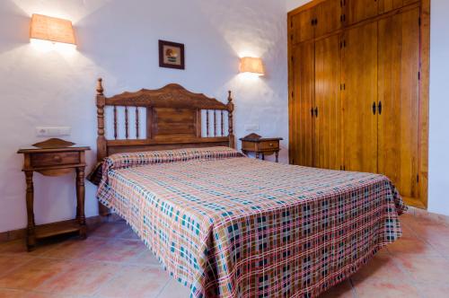 Hacienda Puerto Conil في كونيل دي لا فرونتيرا: غرفة نوم مع سرير وبطانية منقوشة عليه