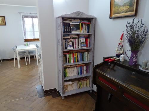 a book shelf filled with books next to a table at Pensjonat Trans in Szklarska Poręba