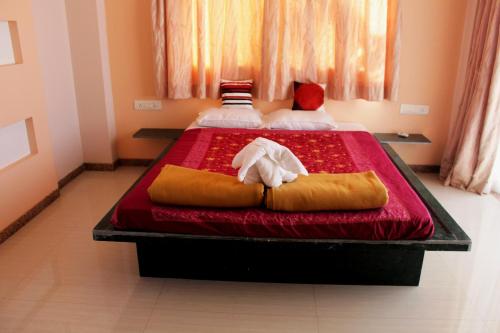 a bedroom with two beds with towels on them at Clifftop in Dapoli