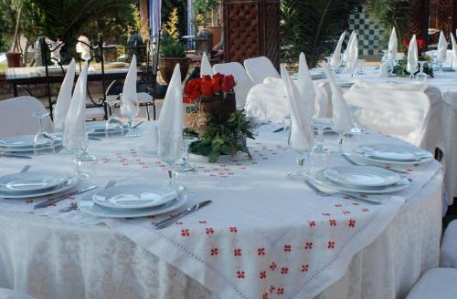 a table with white table cloth and white plates and napkins at Rive Du Lac in Lalla Takerkoust