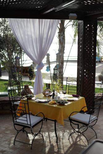 a table with a yellow table cloth and chairs at Rive Du Lac in Lalla Takerkoust