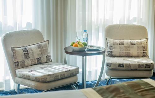 two chairs and a table with a bowl of fruit at CK Farabi Hotel in Ankara