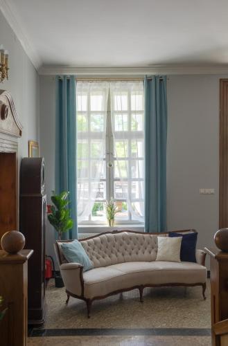 a living room with a couch in front of a window at Dwór w Bychowie in Bychowo