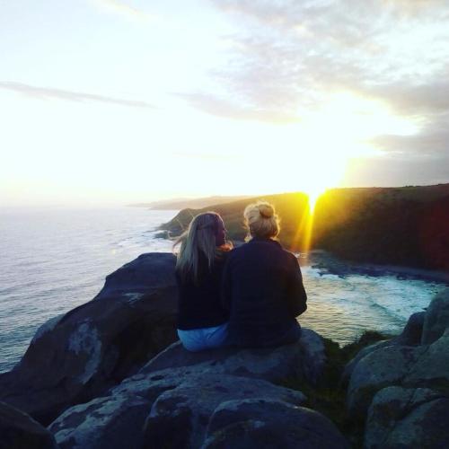 a couple sitting on a rock watching the sunset at Barefoot B&B in Morganʼs Bay