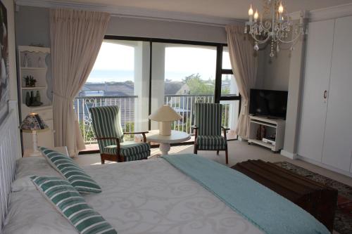 a bedroom with a large bed and a large window at Sit-en-Kyk in Hermanus